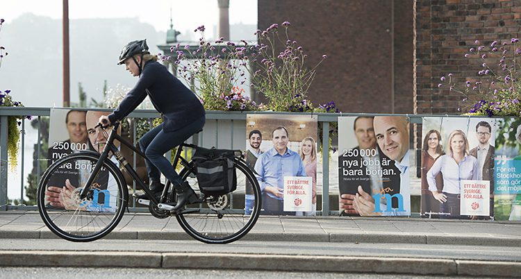 En cyklist cyklar förbi affischer om valet år 2014.