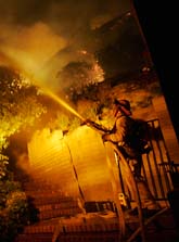 En brandman i Kalifornien spolar vatten på ett hus för att skydda det från bränderna. Foto: Dan Steinberg/Scanpix