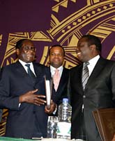 Robert Mugabe och Morgan Tsvangirai tittar på varandra och ler. De ska dela makten i Zimbabwe. Foto: Tsvagirayi Mukwazhi/Scanpix