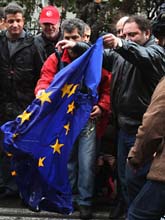 Demonstranter i Grekland bränner en EU-flagga. Foto: Thanassis Stavrakis/AP/Scanpix