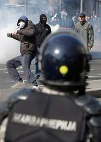 Motdemonstranter i Belgrad kastar stenar på poliserna. Foto: Darko Voijnovic/Scanpix