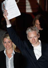 Julian Assange visar lappen som talar om att han får lämna häktet. Foto: Kirsty Wigglesworth/Scanpix