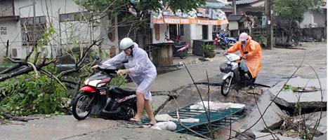 Turister försöker komma fram på en skadad väg på ön Koh Samui. Foto: Apichart Weerawong/Scanpix