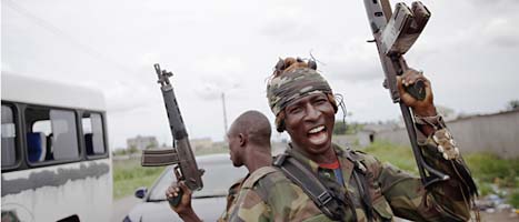 En soldat som stöder Alassane Ouattara jublar när han får veta att motståndarnas soldater har gett upp. Foto: Rebacca Blackwell/Scanpix