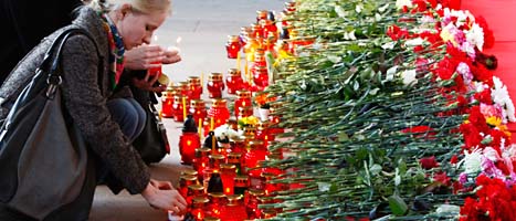En kvinna tänder ljus vid oktoberskaja-stationen i Minsk i Vitryssland.
Människor sörjer dem som dödades i terrordådet i tunnelbanan i måndags. Foto: Sergej gGits/Scanpix