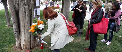 Människor lägger blommor på platsen där en äldre man sköt sig själv i protest mot krisen som gör många fattiga. Foto: Thanassis Stavrakis/Scanpix