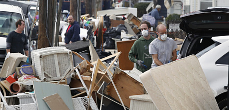 Folk städar efter stormen Sandy i USA. Foto. Mel Evans/Scanpix.
