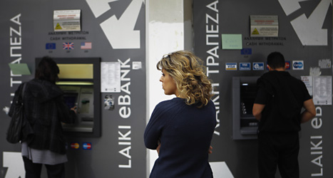 En kvinna står i kö vid en bankomat i Cypern. Foto: Petros Karadjias/Scanpix.