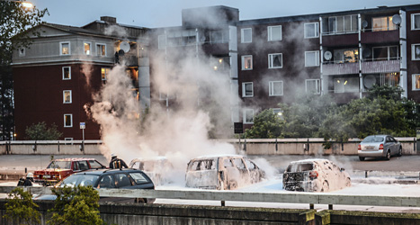 Brandkåren släcker några bilar som ungdomarna tänt eld på. 
Foto: Fredrik Sandberg/Scanpix.