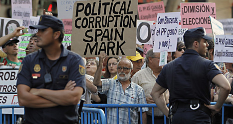 Människor i staden Madrid demonstrerar. De vill att landets regeringschef Mariano Rajoy ska sluta. Foto: Andres Kudacki/Scanpix.