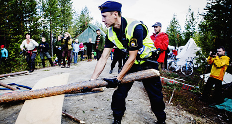 Poliser tar bort hindren från vägen till platsen där gruvan ska sprängas. Foto: Scanpix