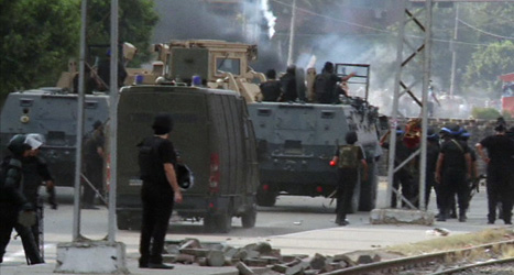 Militärer slänger in tårgas i ett av protestlägren i Kairo innan de går in i det. Foto: AP /Scanpix