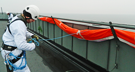 En demonstrant på taket till kärnkraftverket i Oskarshamn. Foto: Greenpeace/TT