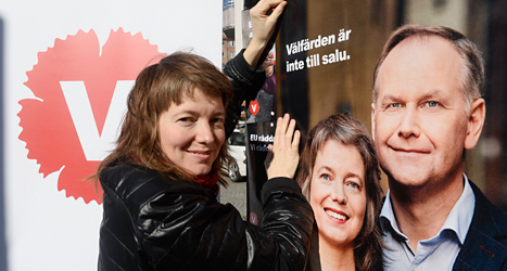 Malin Björk sätter upp en affisch med sitt eget ansikte på. Affischen är reklam för Vänsterpartiet. Foto: TT