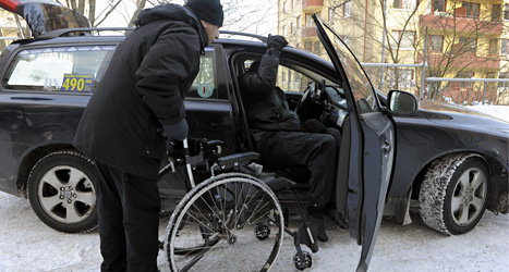 Chauffören hjälper mannen att komma in i taxin. Mannen har färdtjänst. Foto: TT