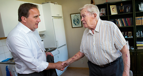 Stefan Löfven hälsar på Helge Person som bor på ett hem för gamla i Bromma. Foto: TT