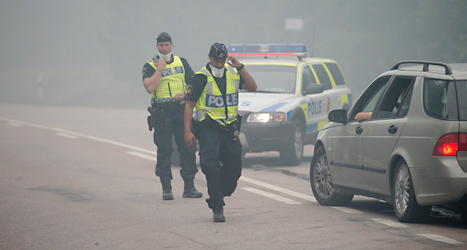 Poliserna stoppar människor från att åka in i området där det brinner. Foto: Fredrik Sandberg, TT