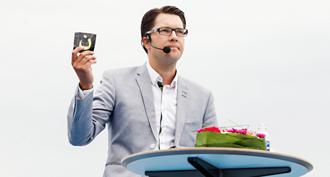 Jimmie Åkesson håller tal och visar upp ett arabiskt tecken som används i koranen. Foto: TT