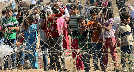 Flyktingar från Syrien väntar på att få komma in i grannlandet Turkiet. Foto: Burhan Ozbilici/TT.