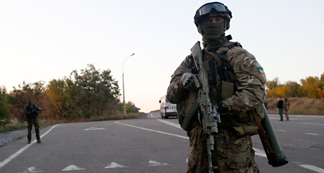 En soldat i Ukraina vaktar en väg. Det är krig mellan olika grupper i landet. Foto: AP/TT