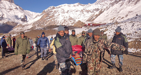 Räddningsarbetare hjälper en man som råkat ut för en lavin i bergen i Nepal. Foto: AP/TT.