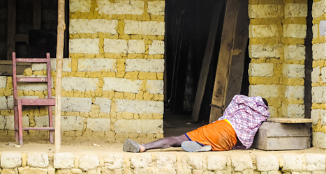 En ebolasjuk man ligger på gatan utanför ett hus i staden Freetown 
i Sierra Leone. Foto: Michael Duff/TT.