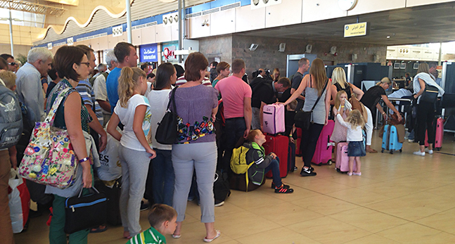 Turister köar på egyptisk flygplats.