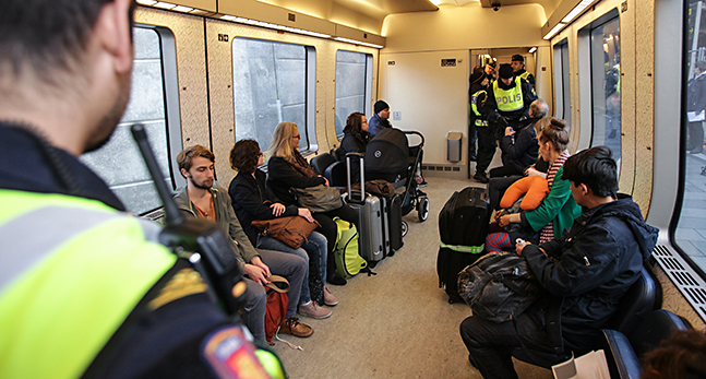 Poliser kontrollerar pass.