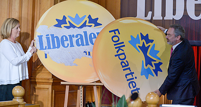 Två skyltar med partiets namn byter plats
