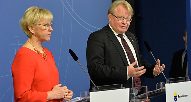 Två ministrar i varsin talarstol.