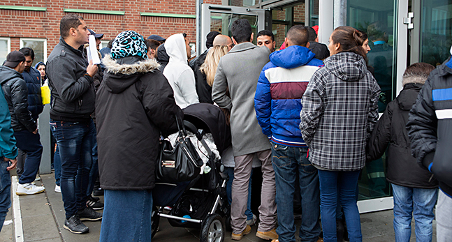 Flyktingar trängs för att komma in på Migrationsverket.