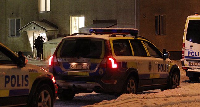 Polisbilar utanför ett hus.