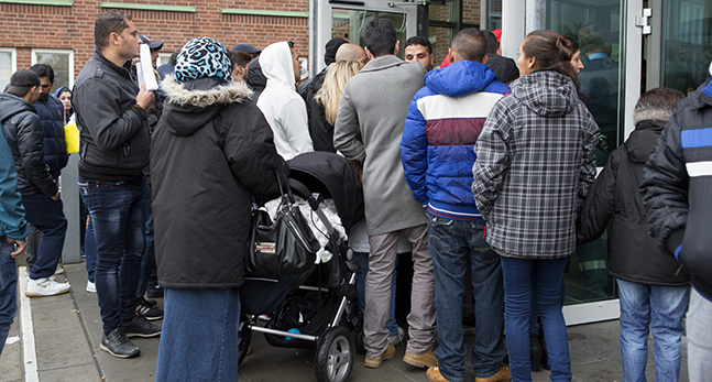 Människor vid Migrationsverket i Malmös entré.
