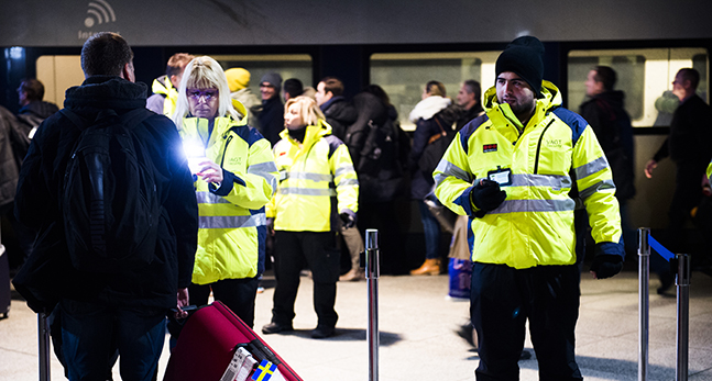vakter kontrollerar pass och id-kort.