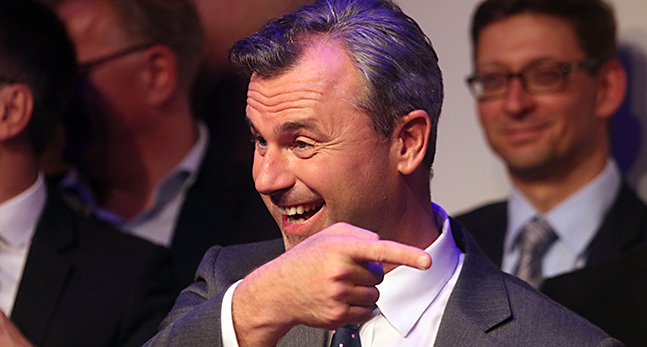 Partiledaren Norbert Hofver gestikulerar med händerna och ler stort.