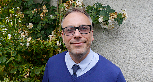 Fredrik Söderquist står framför en vägg