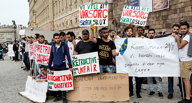 Människor håller upp skyltar med budskap om att ändar lagen