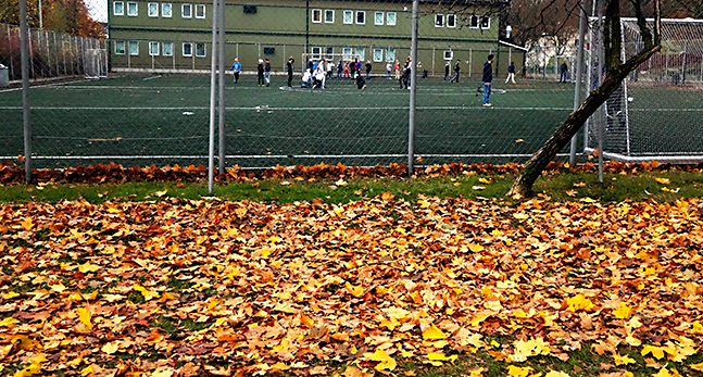 Barn spelar fotboll på en skolgård