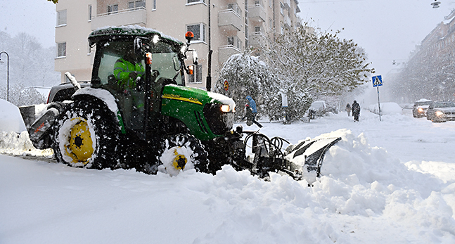 En traktor plogar snö