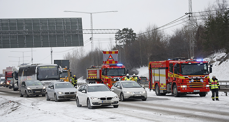Brandbilar står bredvid en kö med bilar