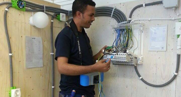 Mehari har arbetskläder och håller på med kablar