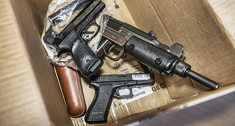 En kartong med flera pistoler i.