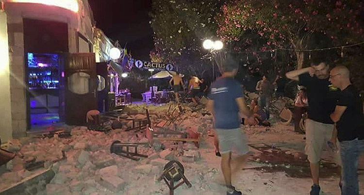 Bitar från ett hus ligger på marken utanför en bar på den grekiska på ön Kos.