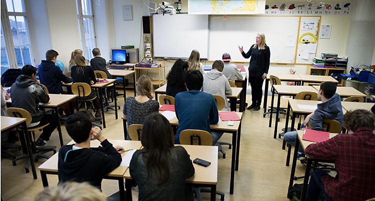 En lärare undervisar en klass i ett klassrum.