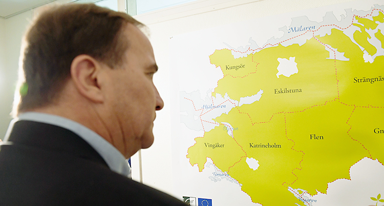 Stefan Löfven tittar på en karta över Sverige.