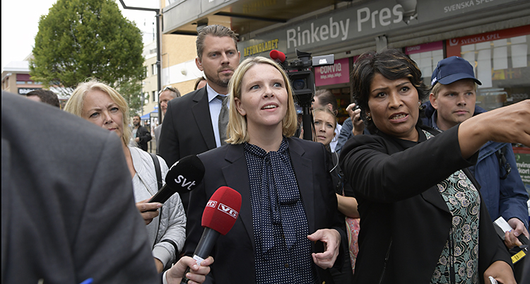 Sylvi Listhaug står i Rinkeby. Runt omkring henne står medarbetare och journalister.