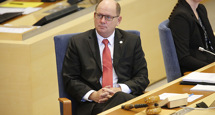 Urban Ahlin sitter på en stol i riksdagen.