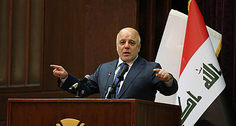 Iraks ledare Haider al-Abadi står vid en talarstol och talar.