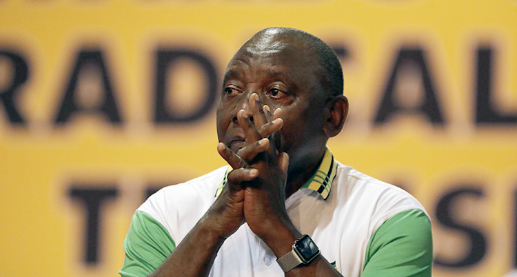 Cyril Ramaphosa sitter med händerna knäppta.