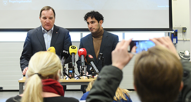 Ministrarna står vid ett bord bakom ett gäng mikrofoner.